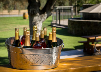 White wines, sparkling wines and rosé chill in a decorated ice bucket, ready for an outdoor event at Cache Creek Vineyards and Winery